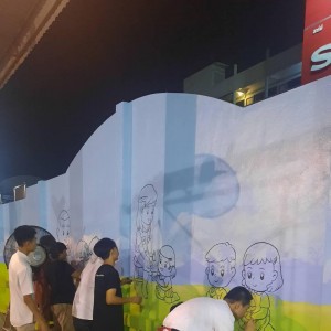  วิทยาลัยช่างศิลป ออกบริการชุมชนวาดสื่อการเรียนรู้สำหรับนักเรียนบนผนังกำแพงด้านหลังป้ายชื่อโรงเรียน